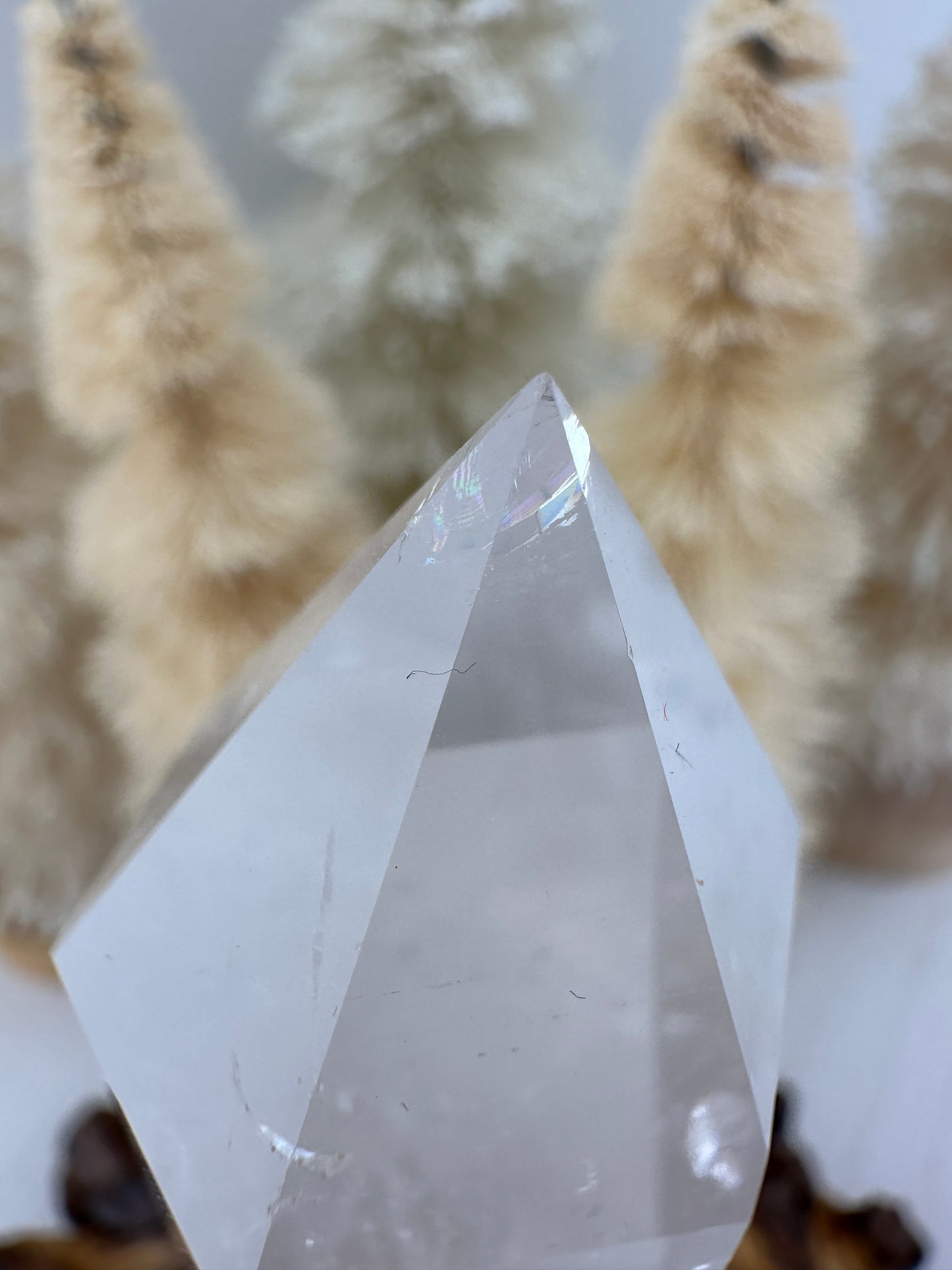 Clear quartz point in wooden stand