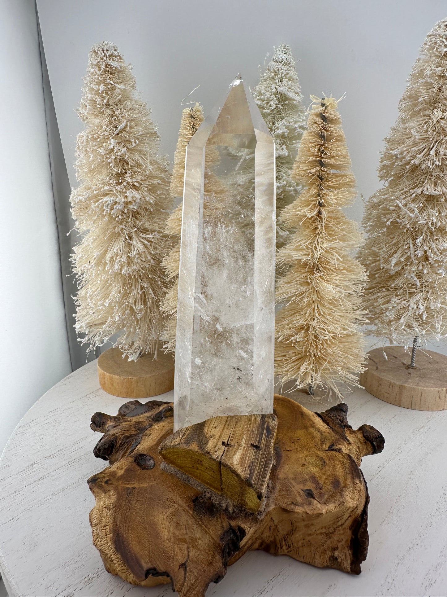 Clear quartz point in wooden stand